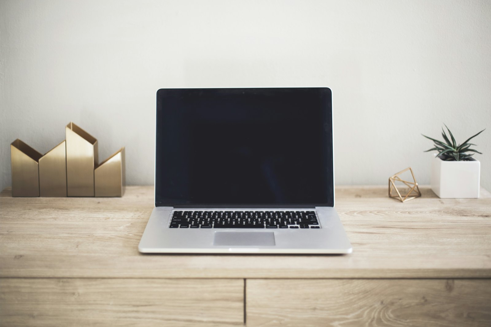 Laptop auf einem aufgeräumten Holzschreibtisch